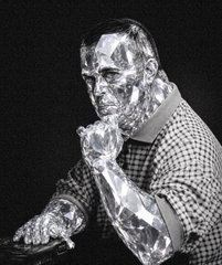 A man rendered entirely in diamond, sitting at a desk in a checkered shirt, chin resting on a crystalline hand