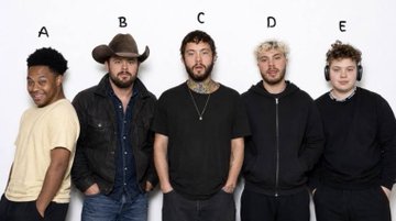 Five men standing in a police-style lineup against a white wall, labeled A through E