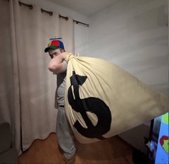 A man in a propeller beanie hoisting an enormous cartoon money bag over his shoulder