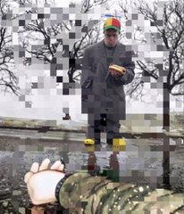 A man holding a hamburger, his face and body pixelated beyond recognition