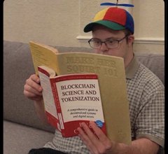 A man in a propeller beanie intently reading a thick book titled Blockchain Science and Tokenization